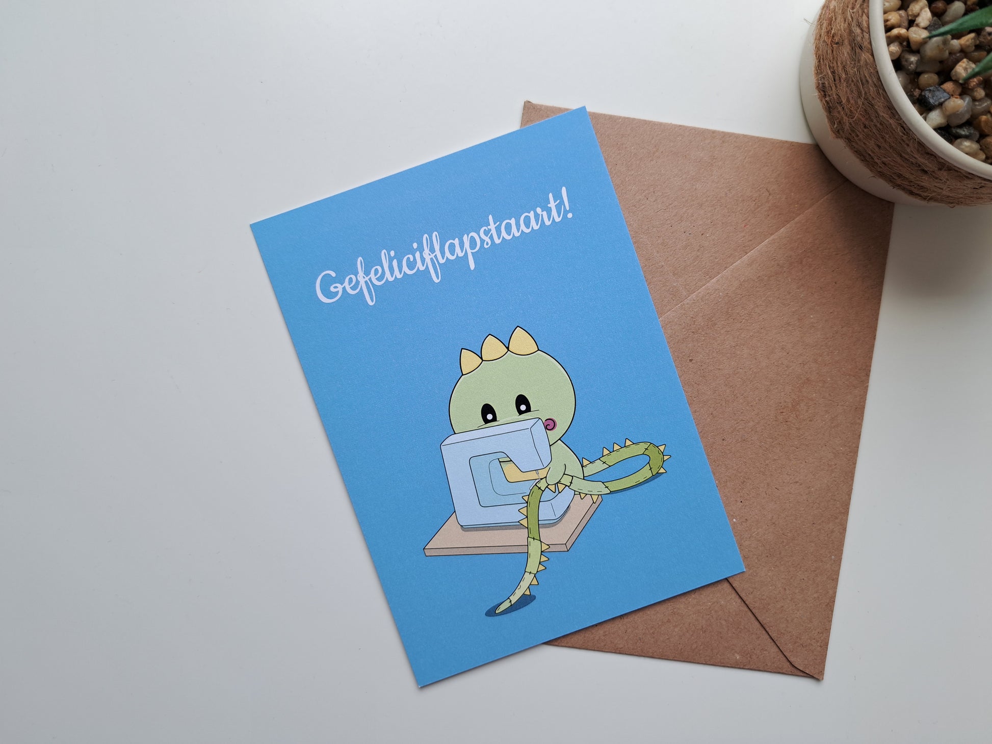 Birthday greeting cardwith Dinosaur sewing himself a longer tail