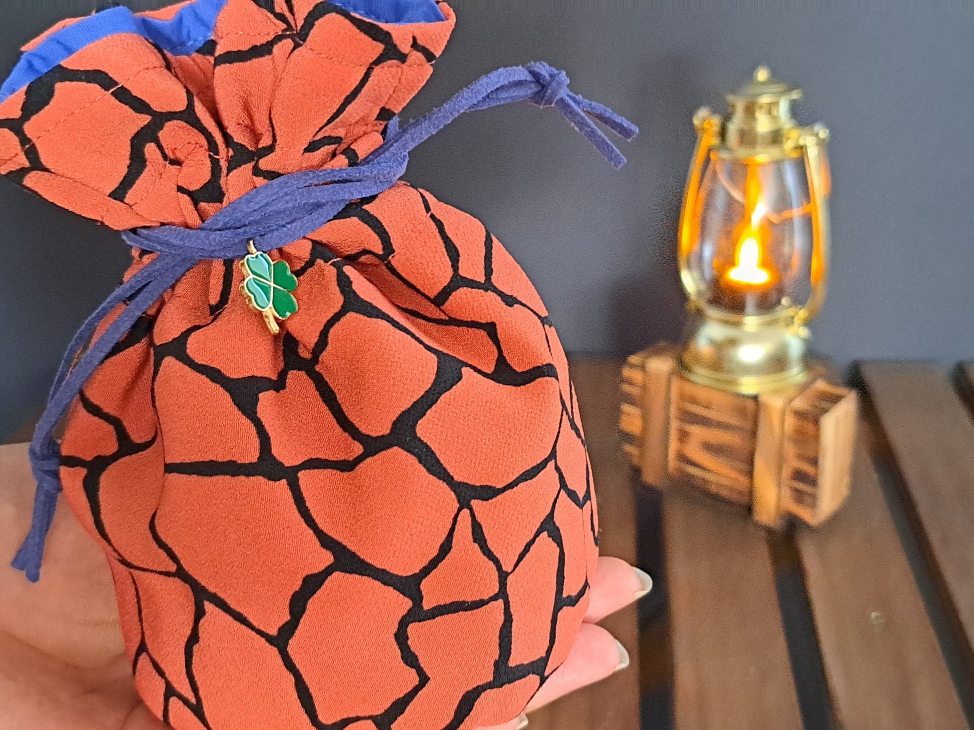 Zoomed in picture of Handmade Dice bag made of orange fabric with black cracks in it
